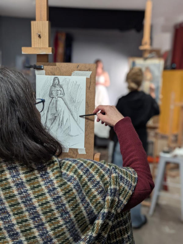 Femme de dos dessinant un modèle en robe de mariée
